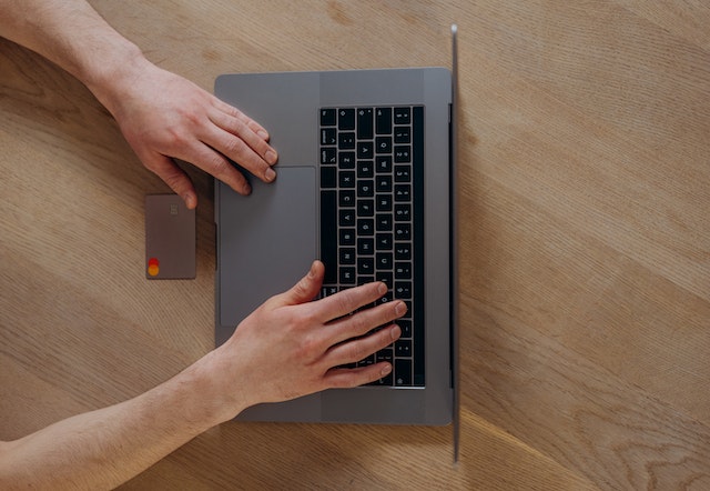 person holding a credit card as they make an online payment